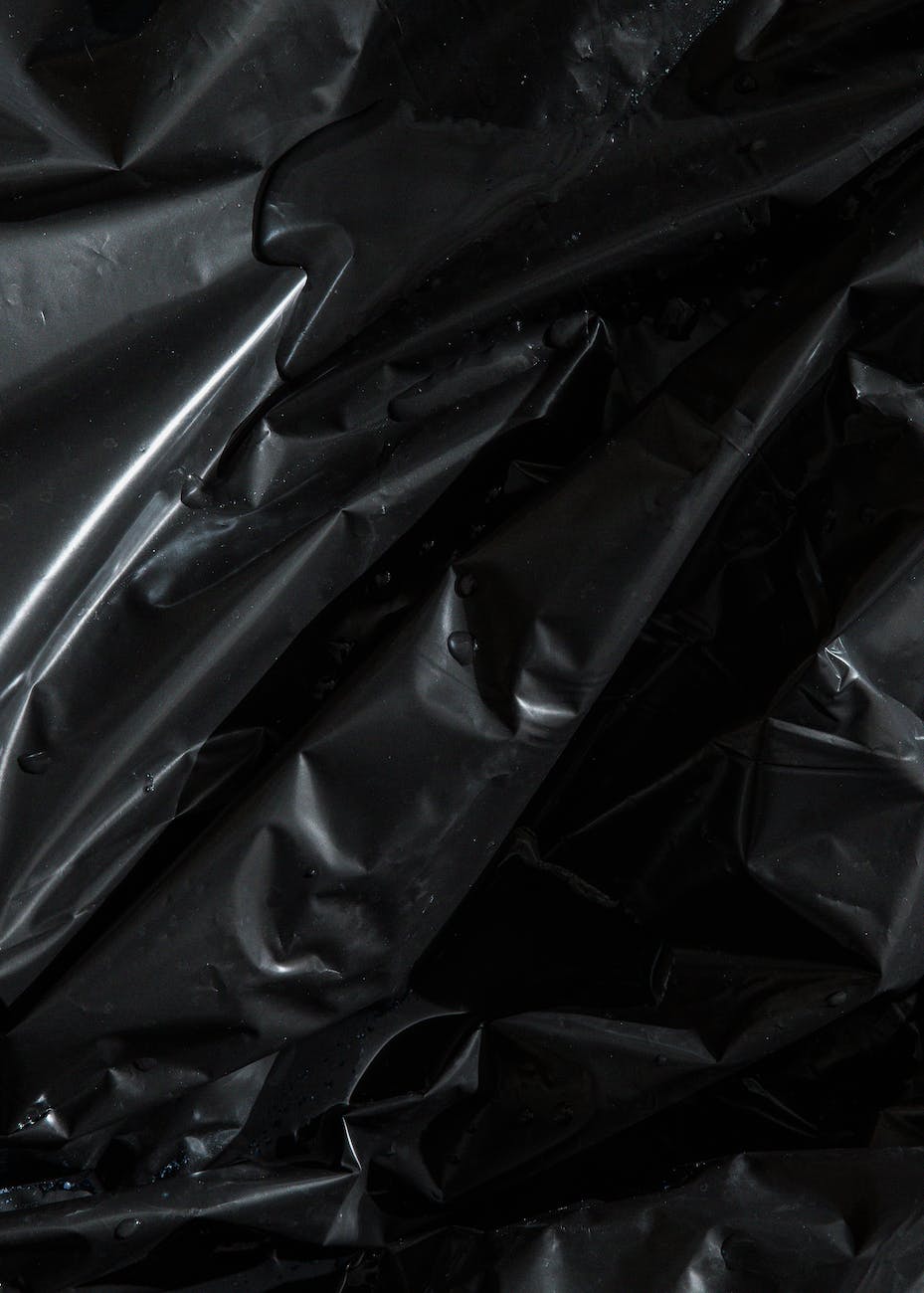From above of smooth surface of black crumpled plastic bag as abstract background